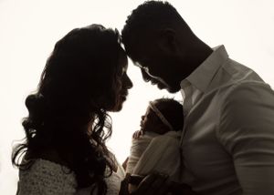 Silhouette of a couple sharing an intimate moment against a white background.