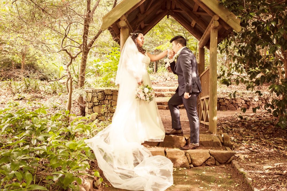 Couple celebrates their wedding moment in a rustic wooden gazebo surrounded by nature.