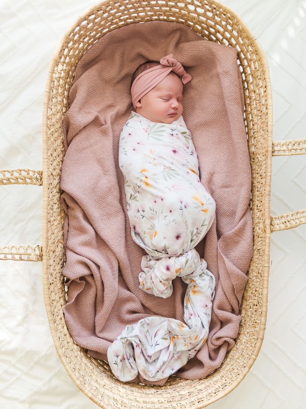 newborn baby in a Moses basket and wearing a bow. Sonoma County