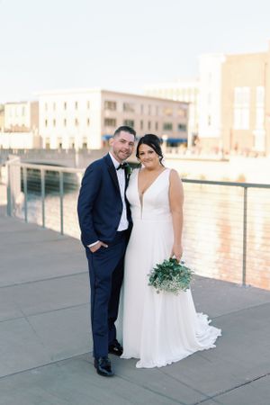 Bride and groom standing portrait on the riverwalk in Janesville. Classic and film-inspired wedding photography in Madison, Wisconsin.