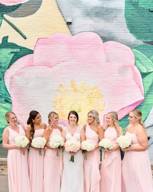 Bridesmaids portrait in front of pink floral mural in Dubuque, Iowa. Classic and film-inspired wedding photography in Madison, Wisconsin.