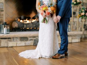 Bride and groom details photo with a fireplace, hands and shoes only. Classic and film-inspired wedding photography in Madison, Wisconsin.