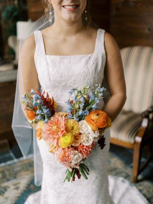 Indoor bride portrait with window light showing off dress and bouquet. Classic and film-inspired wedding photography in Madison, Wisconsin.