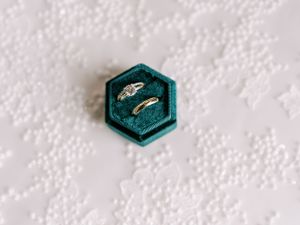 Detail image of wedding rings in emerald color ring box. Classic and film-inspired wedding photography in Madison, Wisconsin.