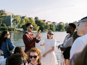 Wedding party on Betty Lou cruise on Lake Mendota, candid photo. Classic and film-inspired wedding photography in Madison, Wisconsin.