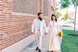 Bride and groom candid portrait walking holding hands outdoors. Classic and film-inspired wedding photography in Madison, Wisconsin.