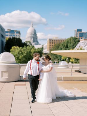 Monona Terrace rooftop portrait of a bride and groom walking fountain. Classic and film-inspired wedding photography in Madison, Wisconsin.