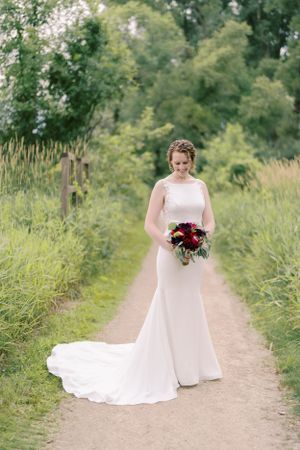 Portrait of a bride outdoors on a walking path in the summer. Classic and film-inspired wedding photography in Madison, Wisconsin.