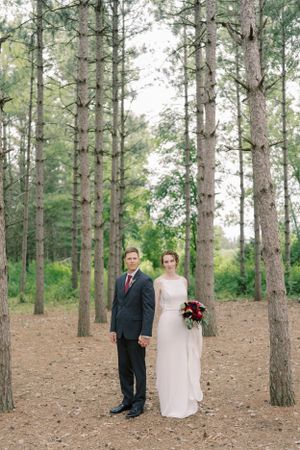 Bride and groom serious portrait in a pine wooded forest. Classic and film-inspired wedding photography in Madison, Wisconsin.
