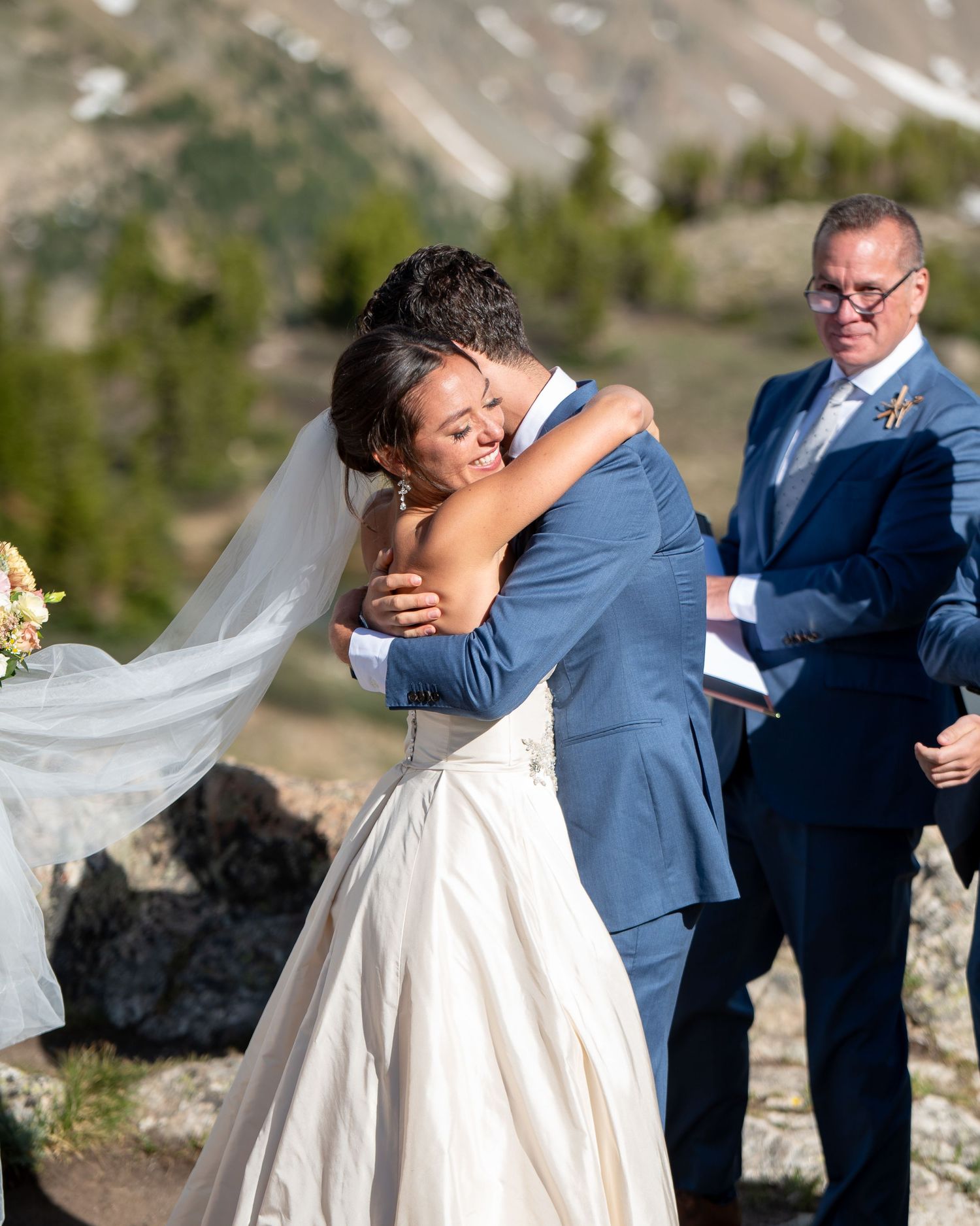 An emotional wedding moment captured during the ceremony in a scenic mountain setting.