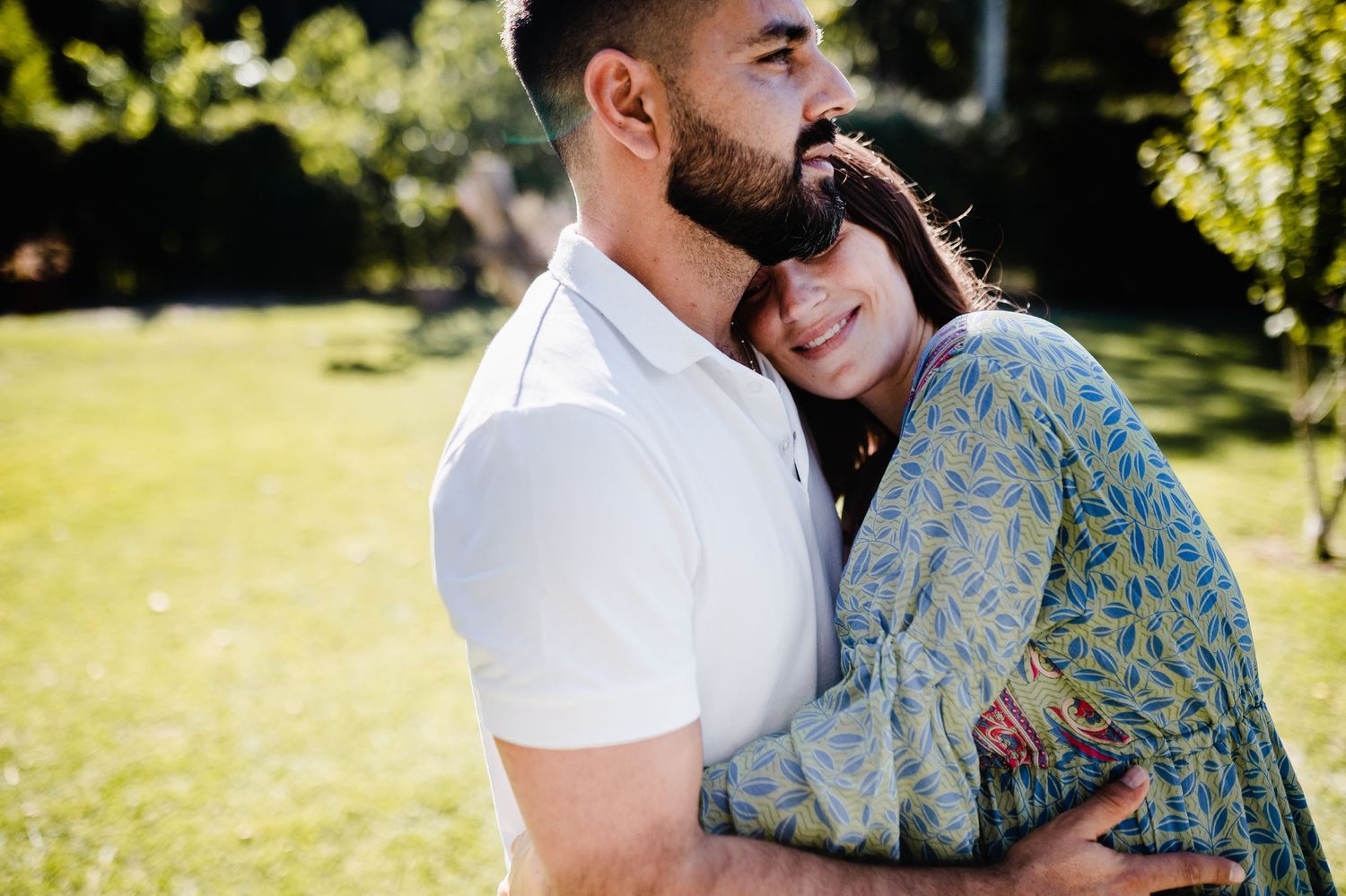 Couple shares romantic moments during a sunlit outdoor photography session.