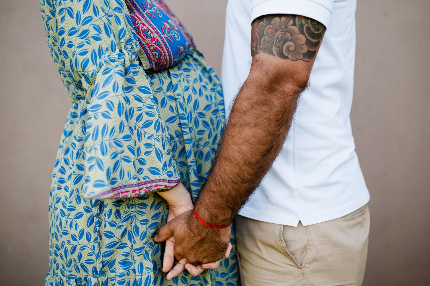 Close-up shots of a couple in blue floral dress and white shirt against a neutral backdrop.