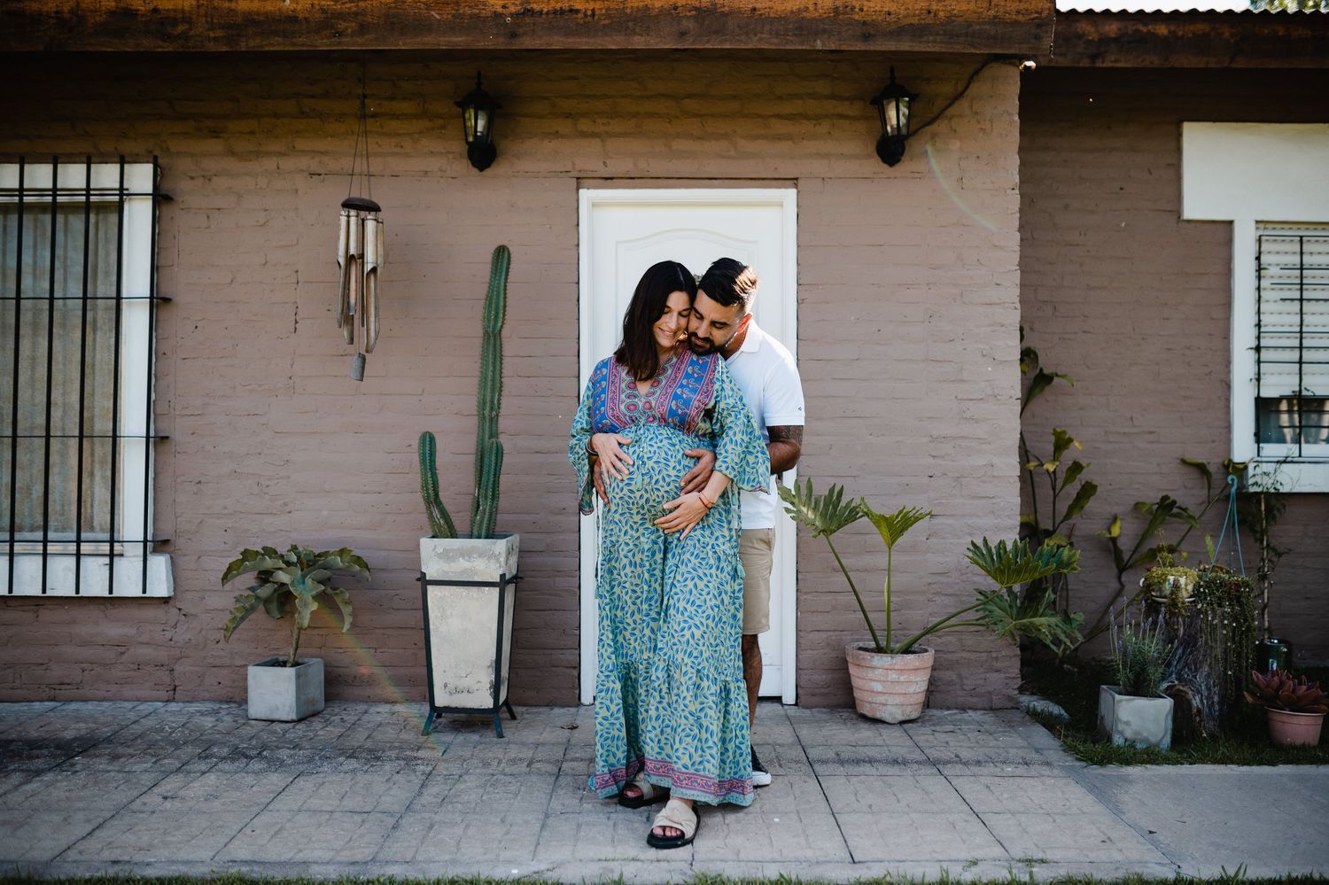 Wide angle shot of a couple sharing an intimate moment on a covered porch.