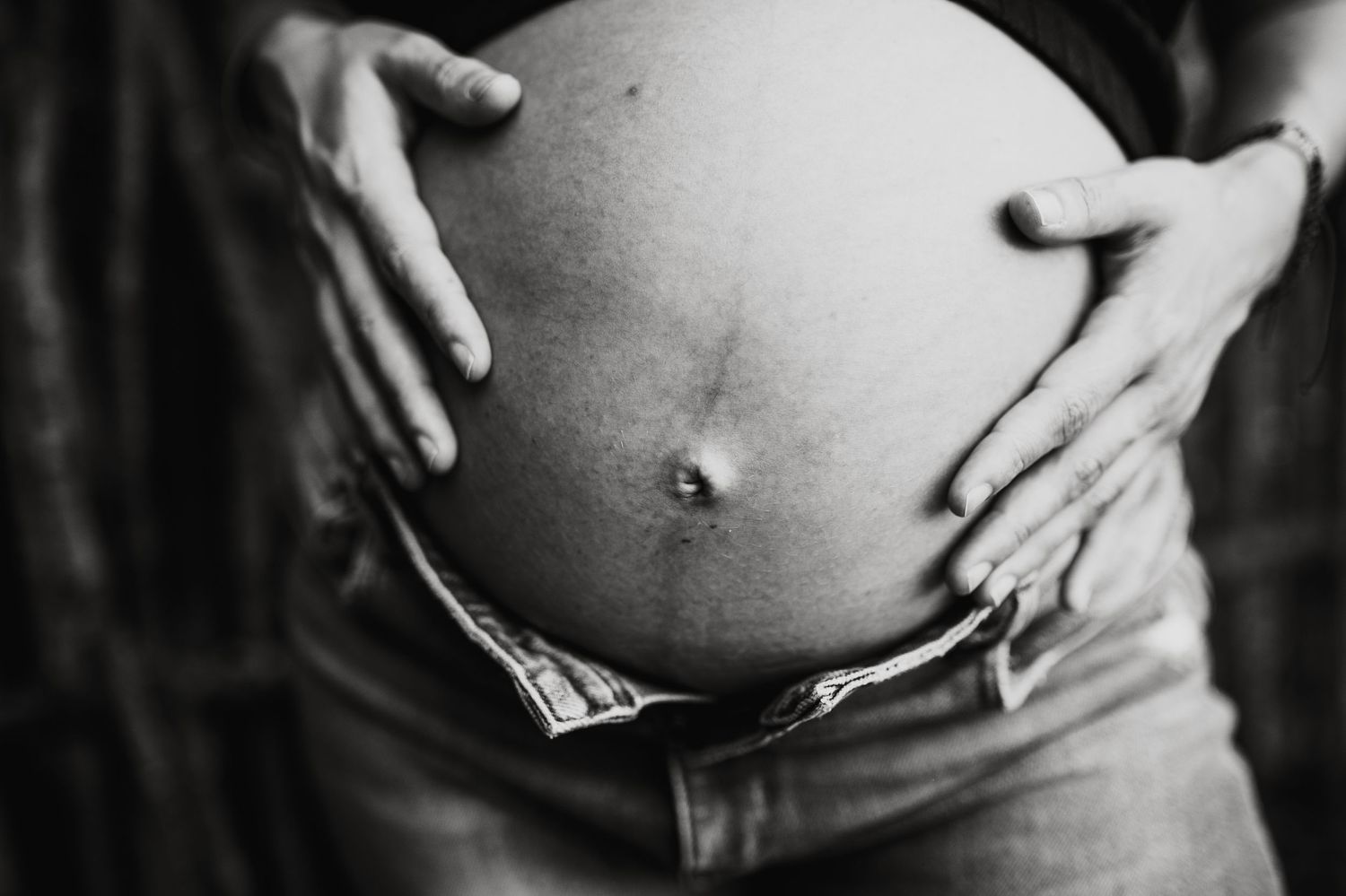A pregnancy progression photo series showing a growing baby bump against a light background.