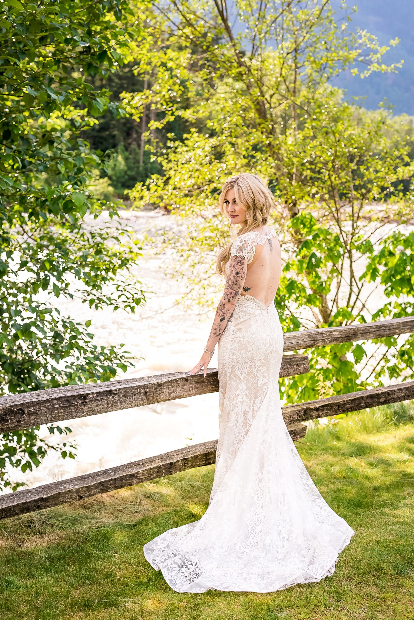 A stunning bride shows of the back of her dress. Photo by Fraser Valley wedding photographer, Kari Mills Photography.
