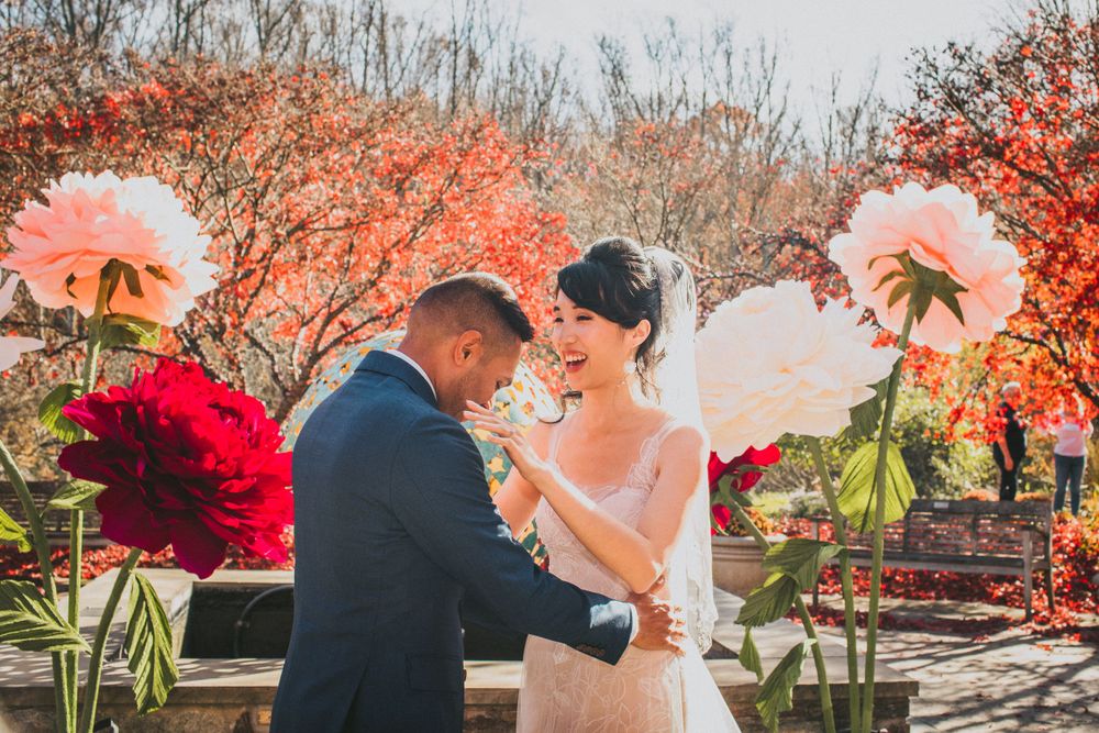 Groom is in awe of bride at first look at Brookside Gardens with fall foliage as backdrop