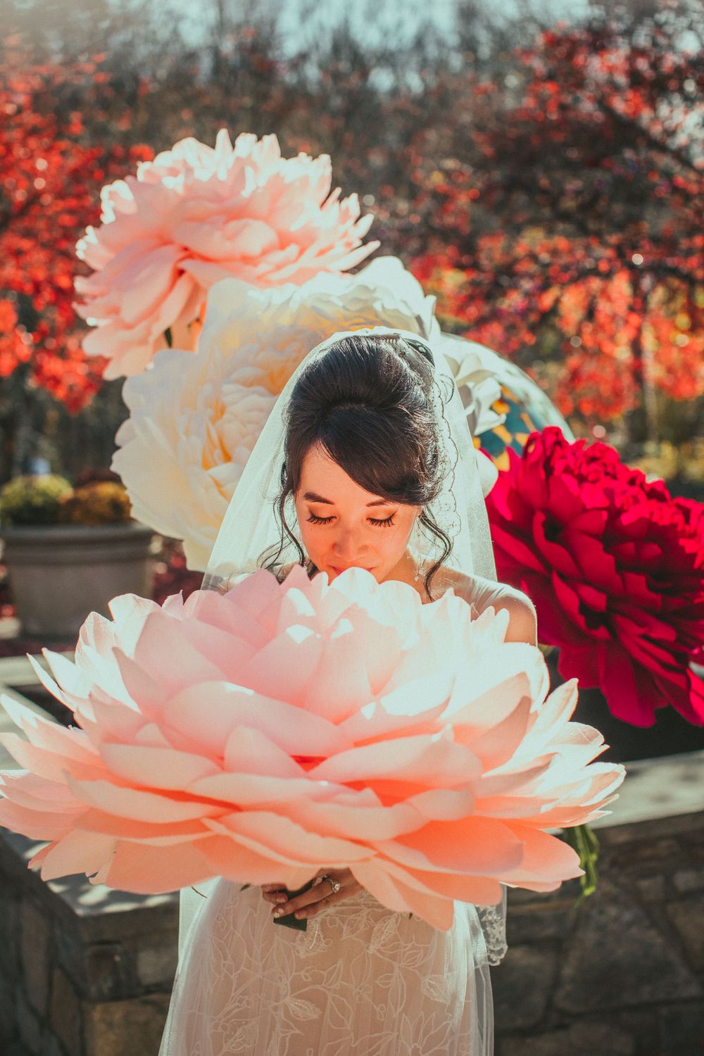 Bride posing a large DIY paper flower at a Brookside Gardens wedding