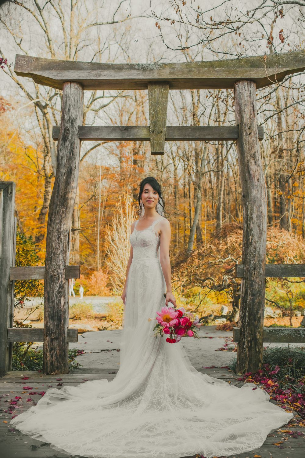 Full body portrait of bride holding bouquet at entrance to Japanese Tea House at Brookside Gardens before wedding.