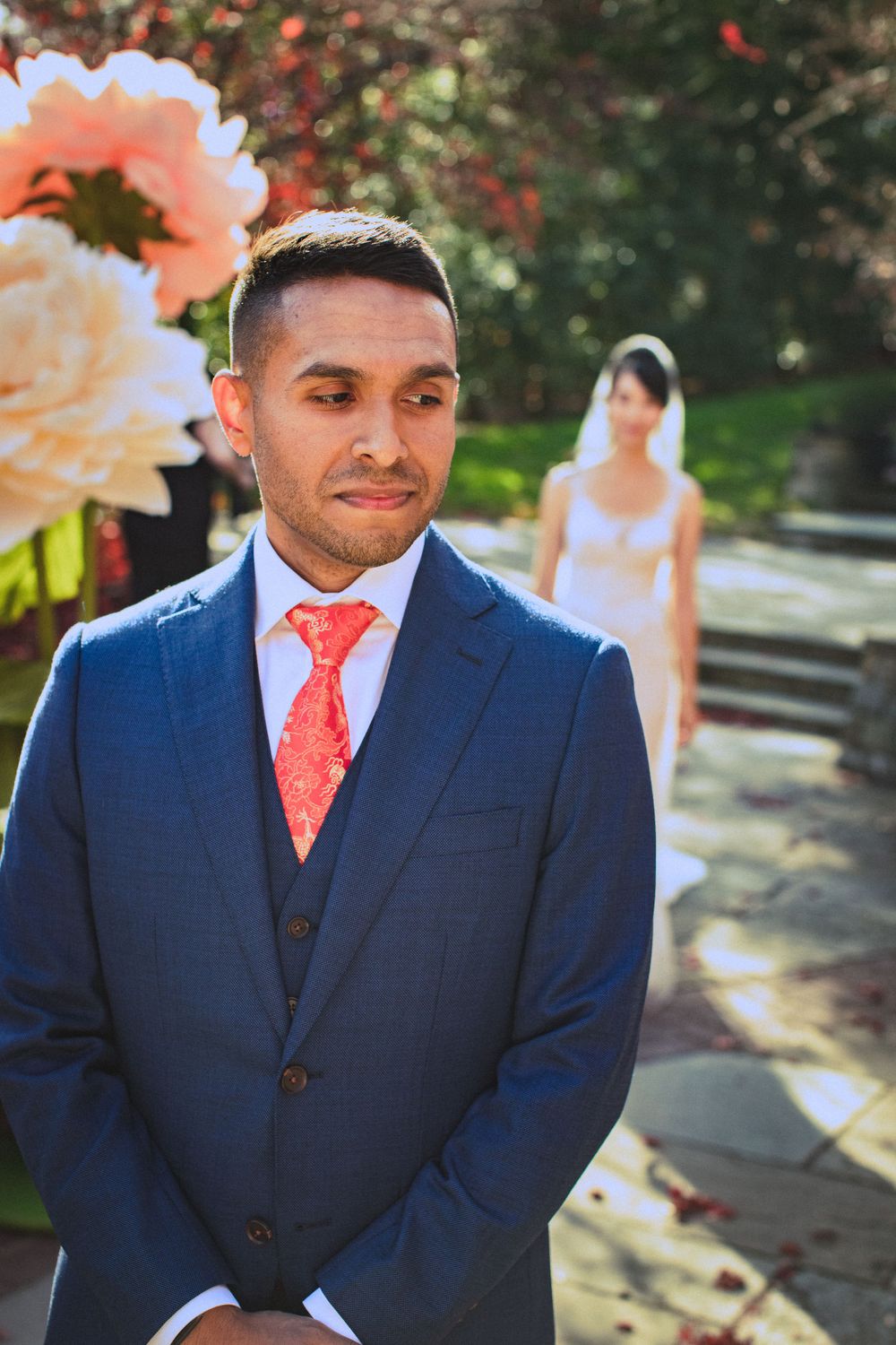 Brookside Gardens wedding with fall foliage. Groom waiting as bride walks up from behind for first look