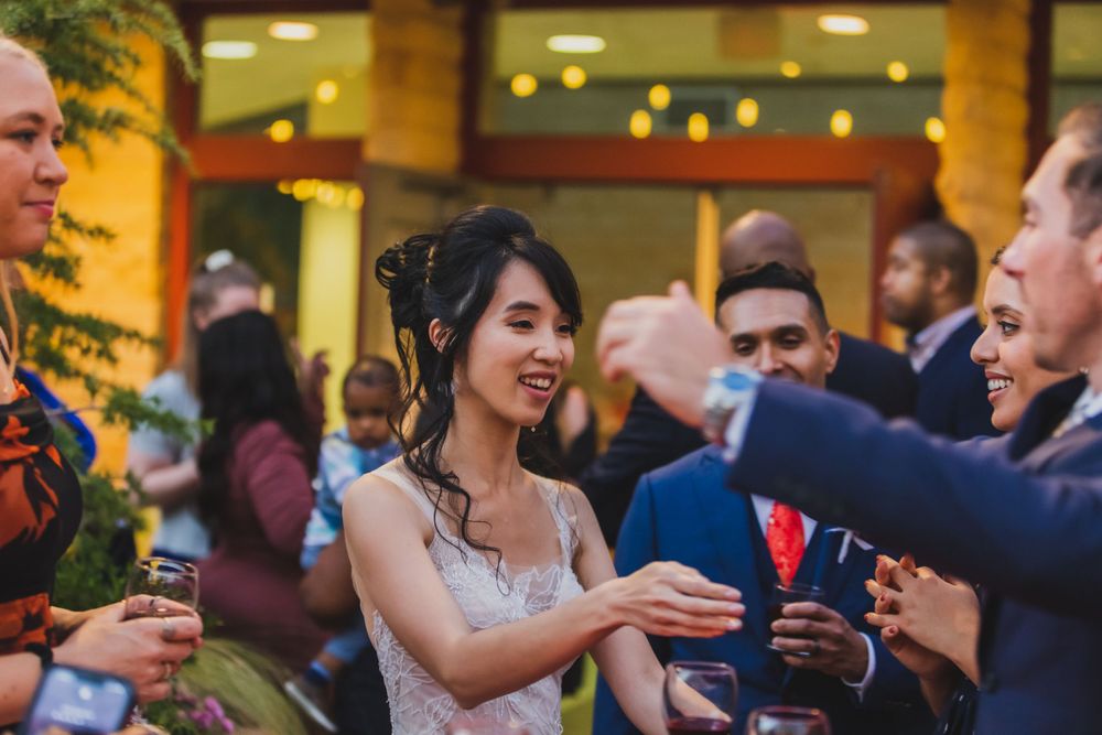 Wedding reception party with guests dancing and celebrating in festive indoor venue.