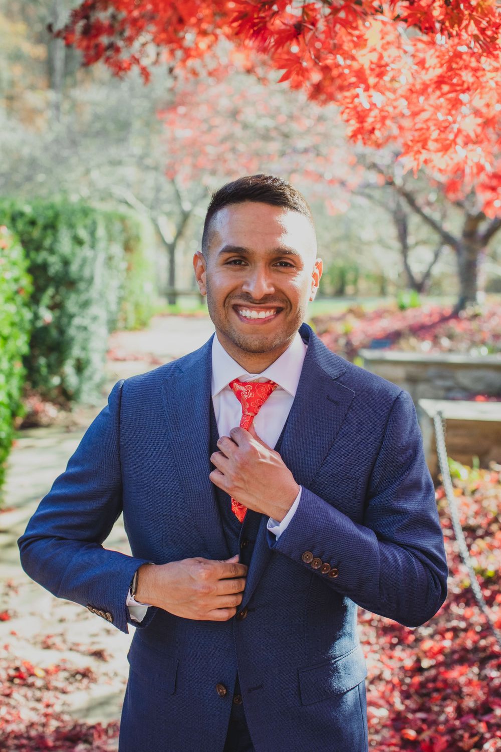 Brookside Gardens wedding with fall foliage. Groom striking a smile while posing