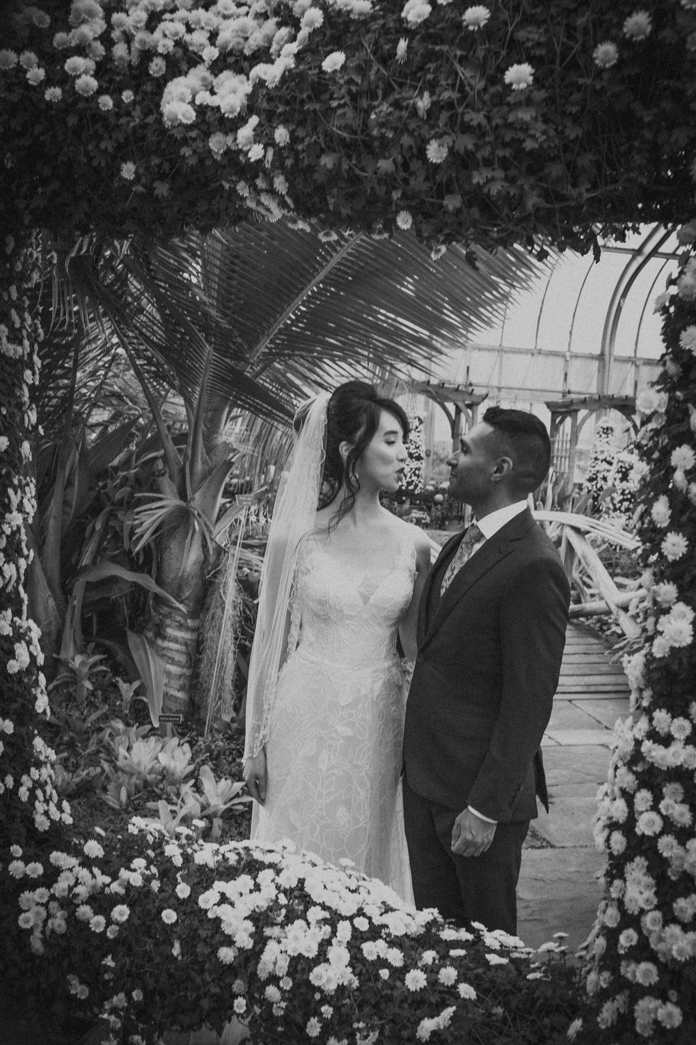 Bride and groom framed by floras inside the Brookside Gardens Conservatory