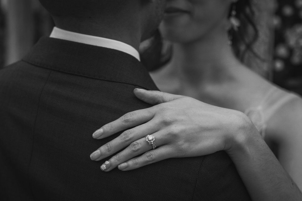 Intimate angle of bride posing with groom showing off wedding ring at Brookside Gardens.