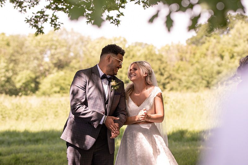 bride and groom smiling at eachother