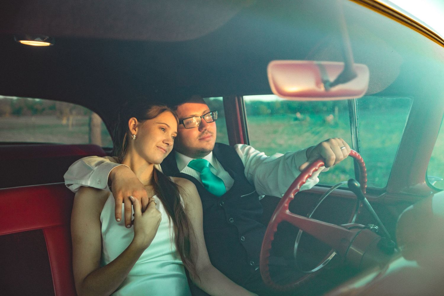 Romantic vintage-tinted scene inside a classic car with soft lighting.