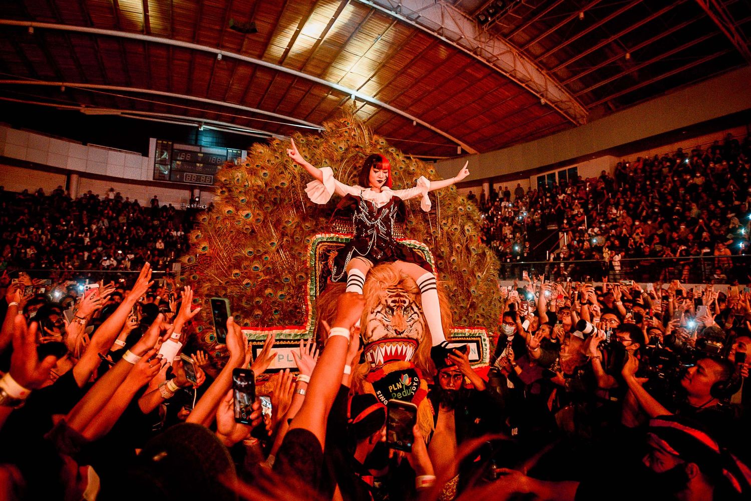 High-energy concert scene with crowd surfing over enthusiastic audience.