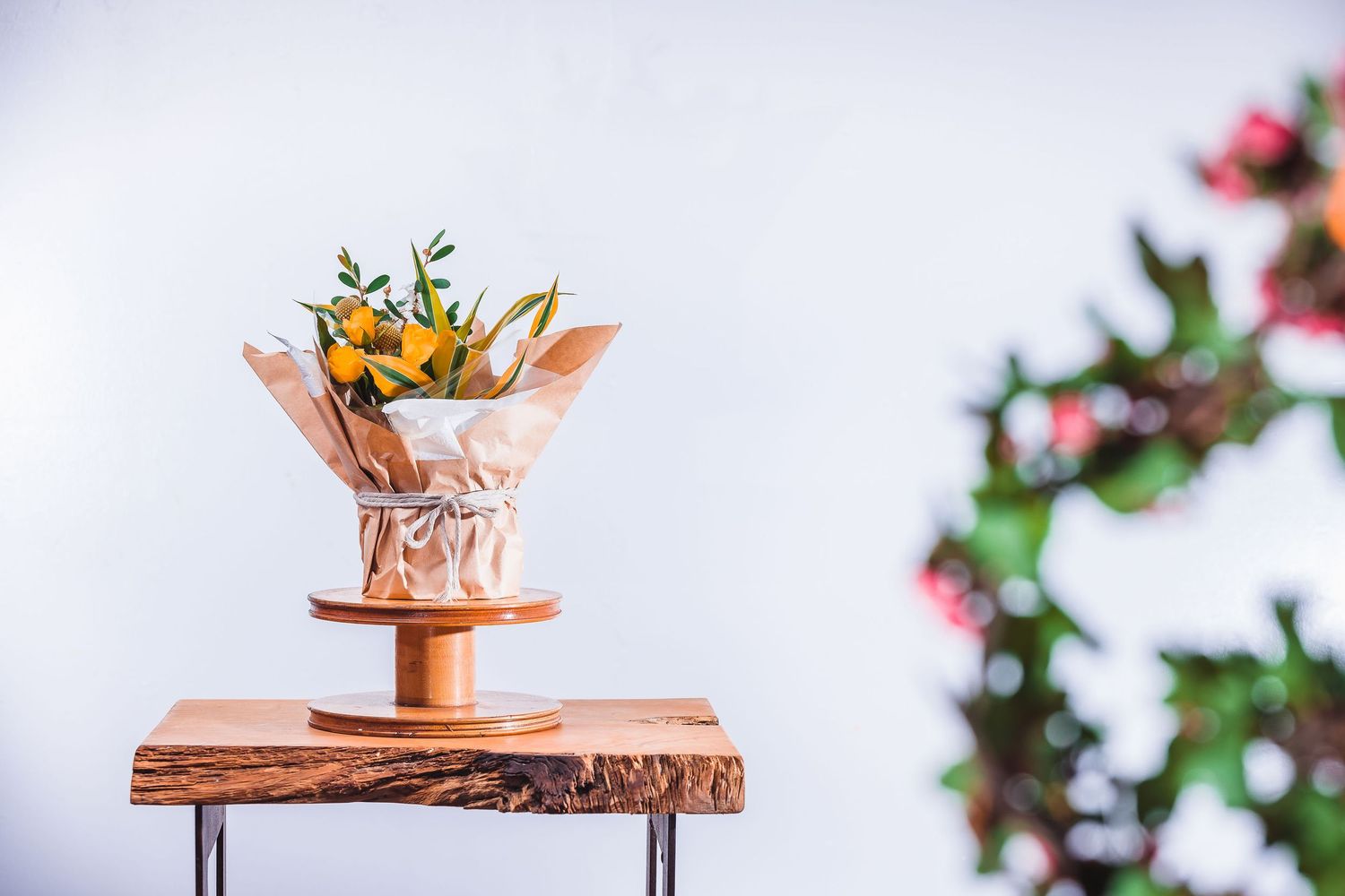 Delicate floral arrangement in copper pour-over coffee filter on wooden table.