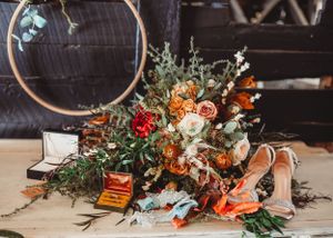 Wedding floral arrangements with orange and white flowers in rustic style.