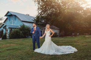 Wedding photography session at sunset with a light blue farmhouse in the background.