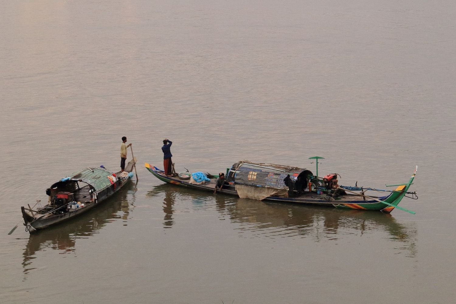 Traditional wooden boats gather on calm waters during golden hour.