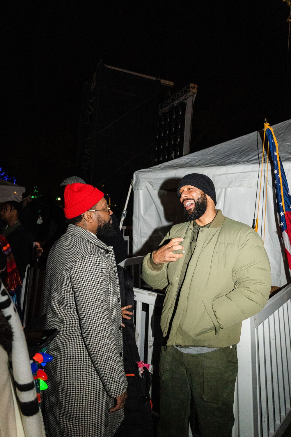 PJ Morton talks to rapper/actor Common backstage at a Christmas tree lighting event in the Boston Commons