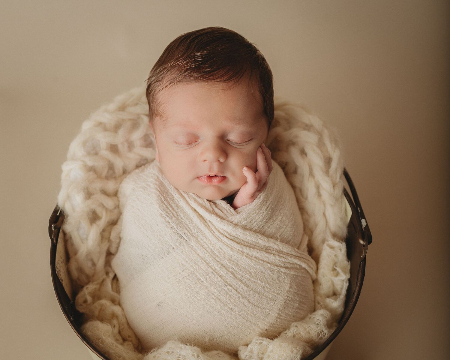 baby in bucket cream swaddle newborn