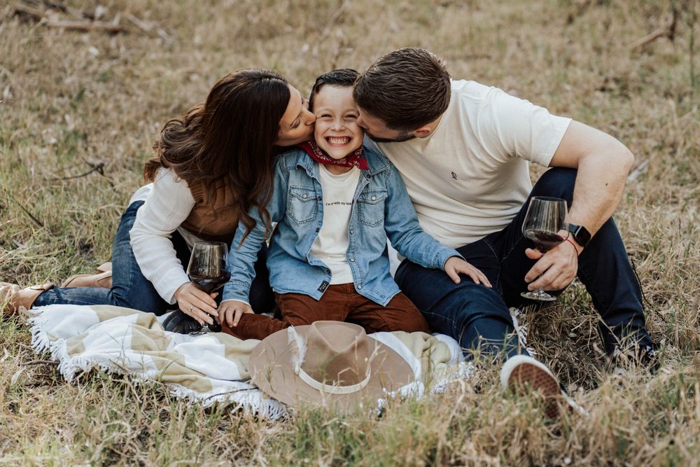 Family sitting together on grass during an outdoor photo session.