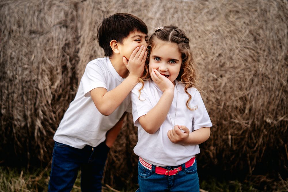 Family sharing playful moments together in front of rustic backdrop.