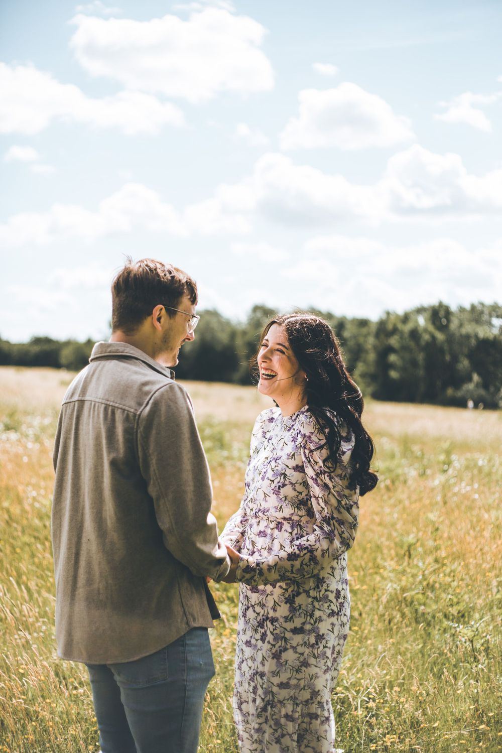 A candid moment captured in a golden field with soft natural lighting.