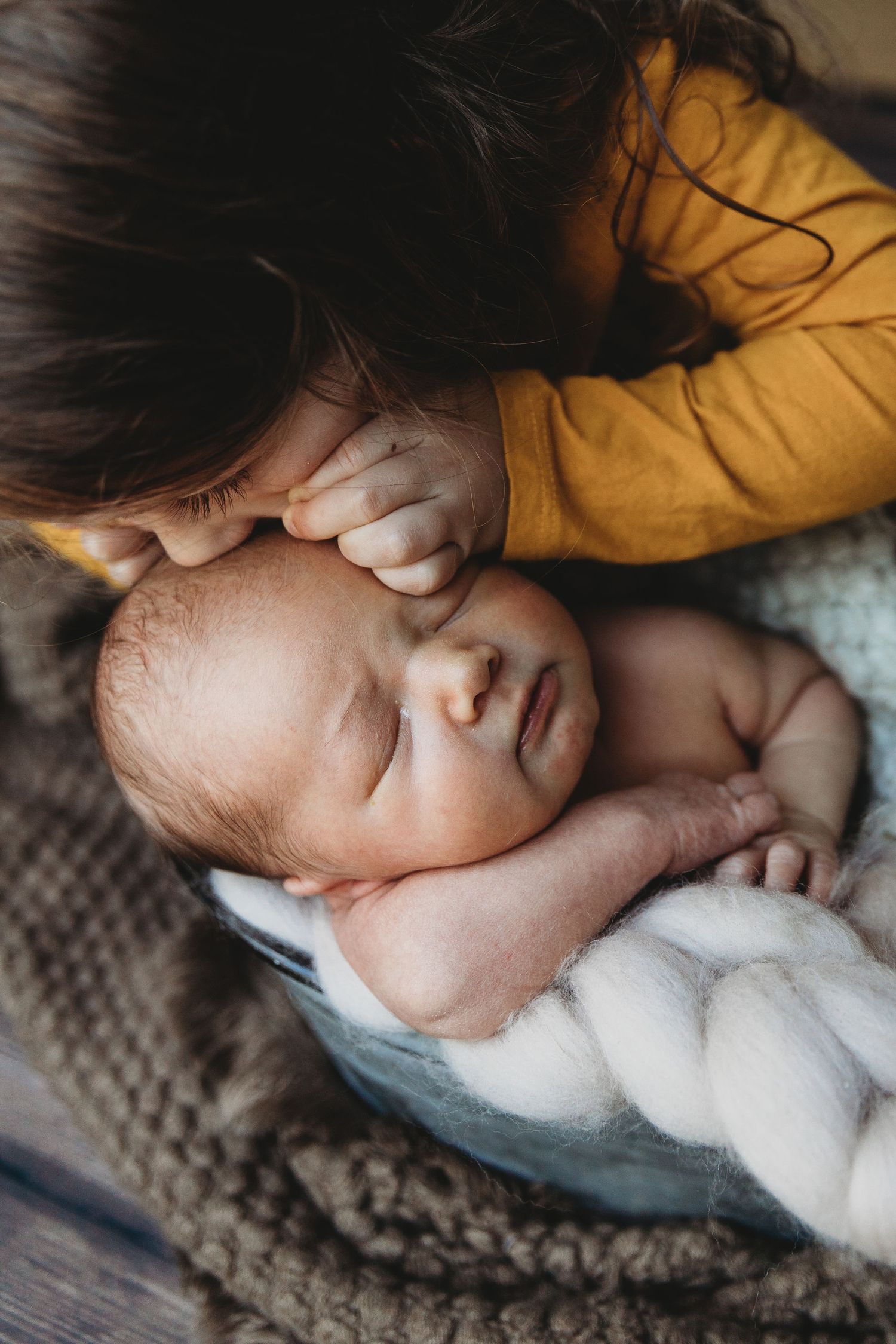 Close-up of sleeping baby on textured grey blanket.