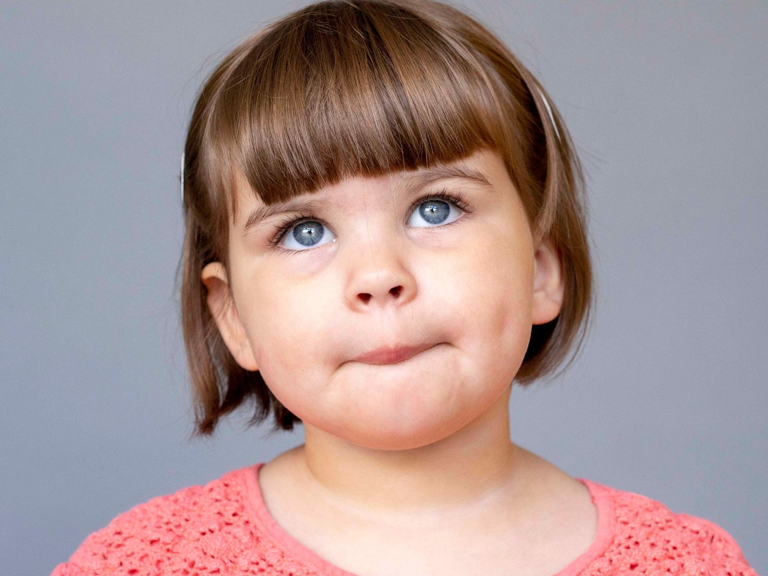Pre-school aged girl, solid grey background.