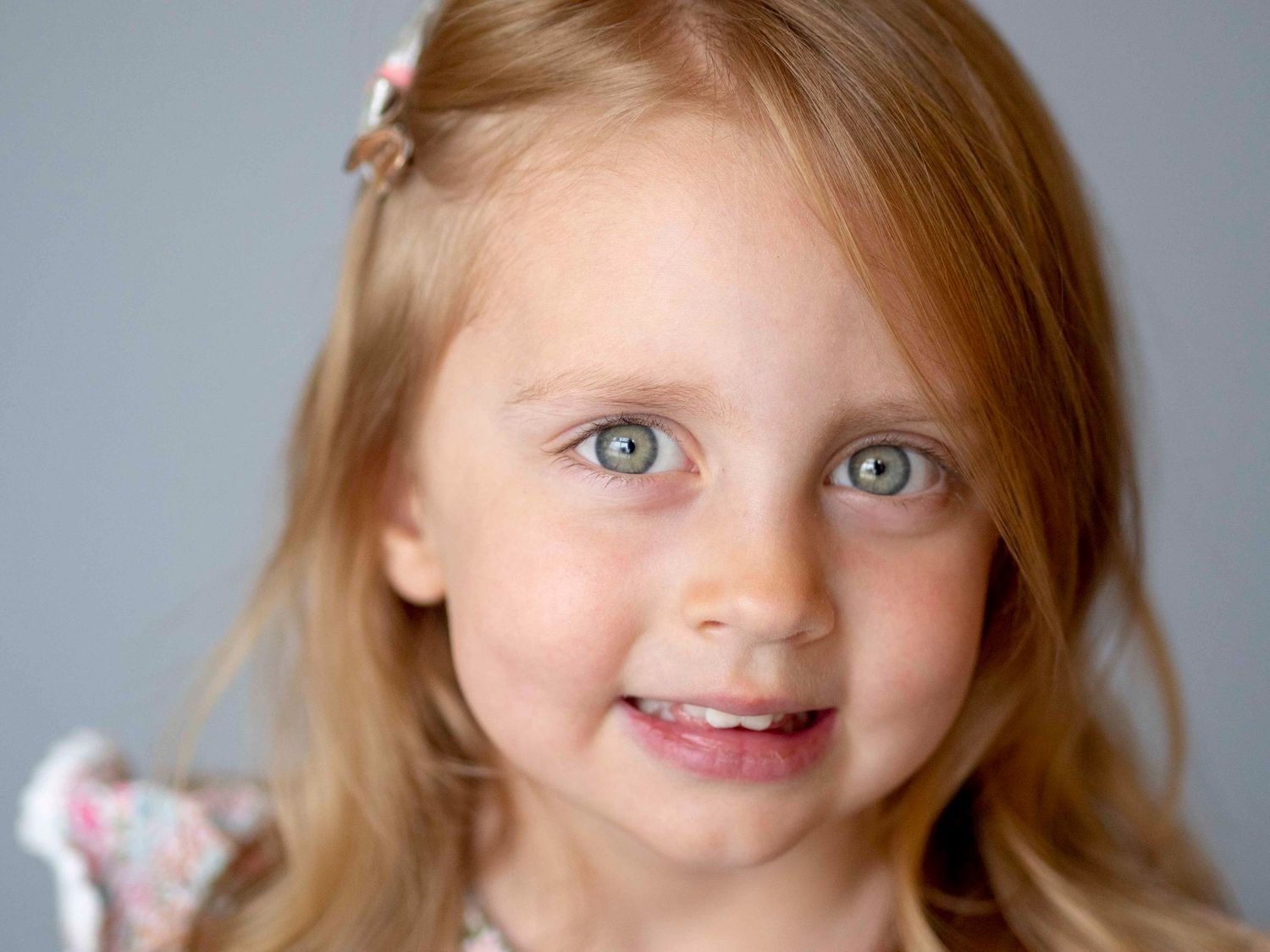 Pre-school aged girl, solid grey background.