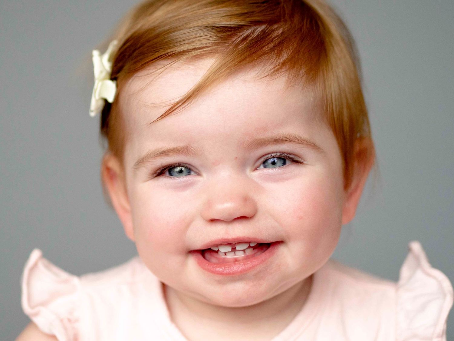 Toddler aged girl, solid grey background.