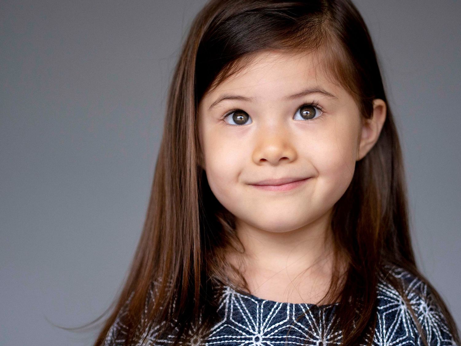 Pre-school aged girl, solid grey background.