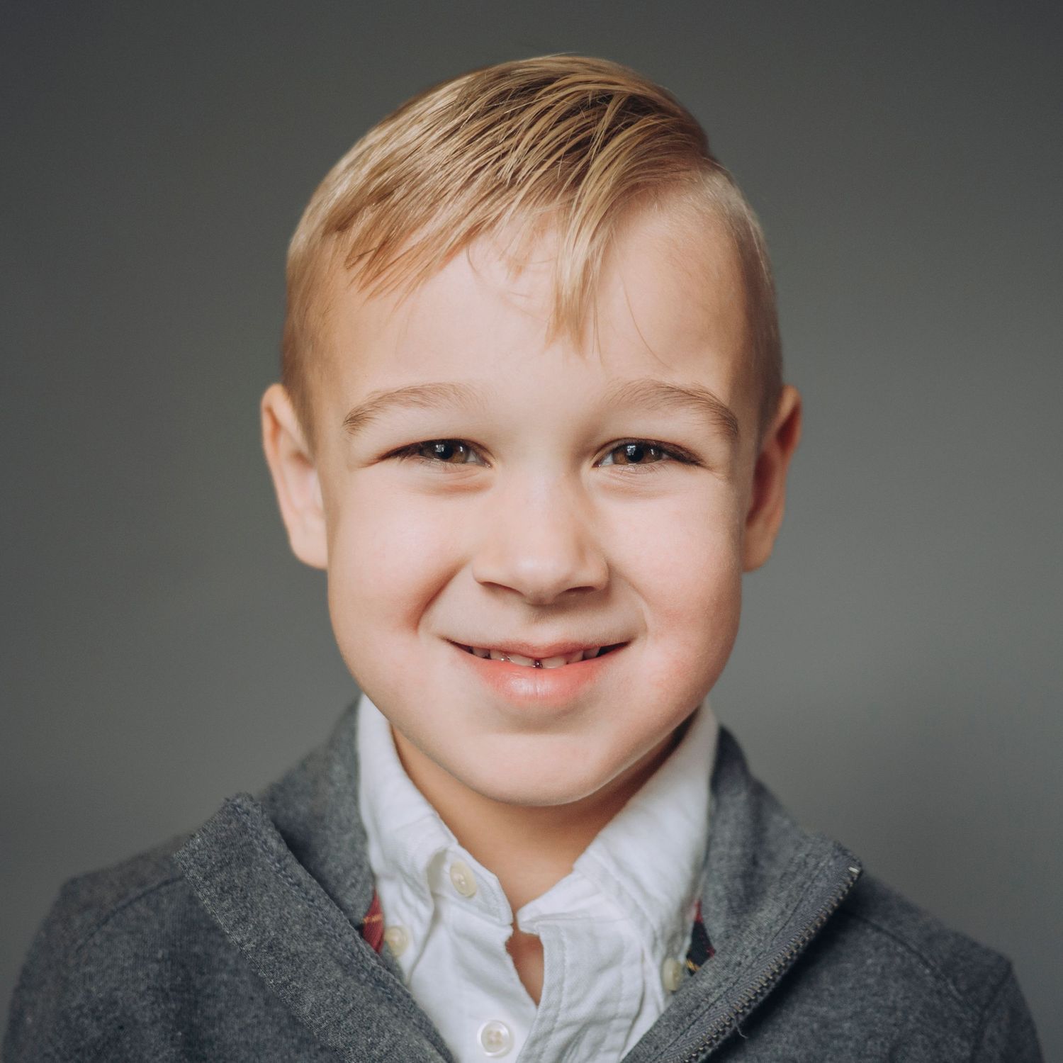 Pre-school aged boy, solid grey background.