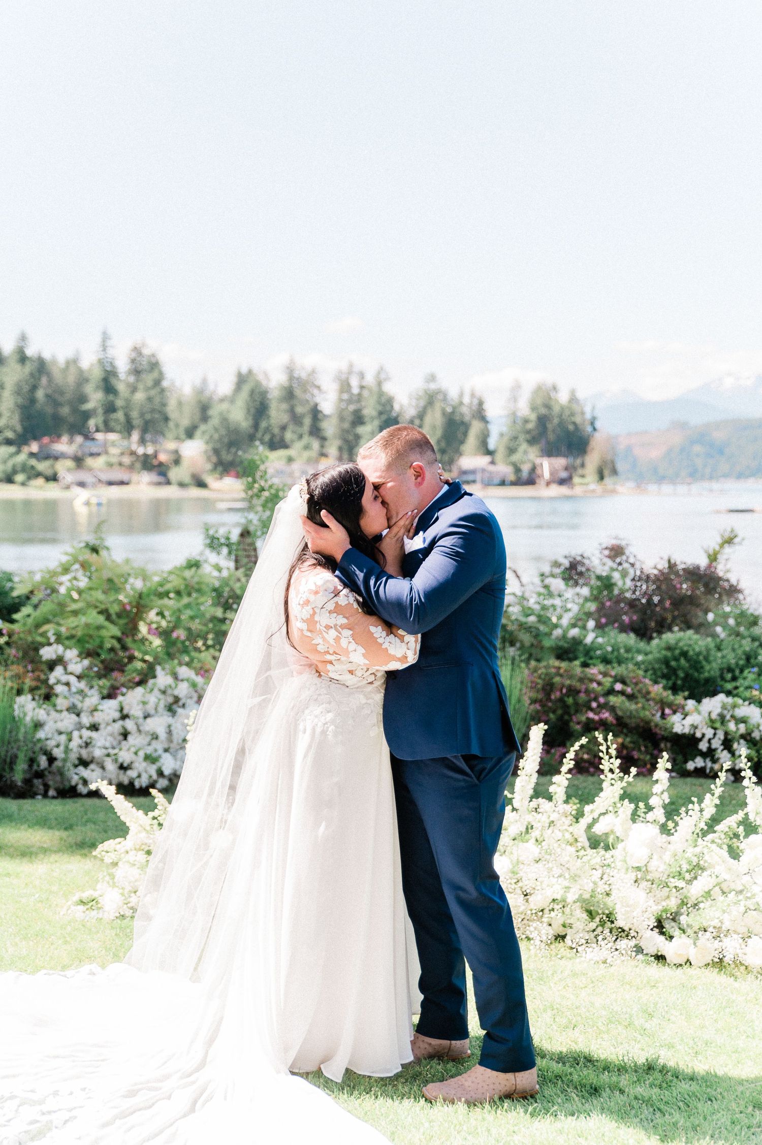 Bride and Groom first kiss with mountains in background. Photo by Bremerton wedding photographer, Pine + Vow.