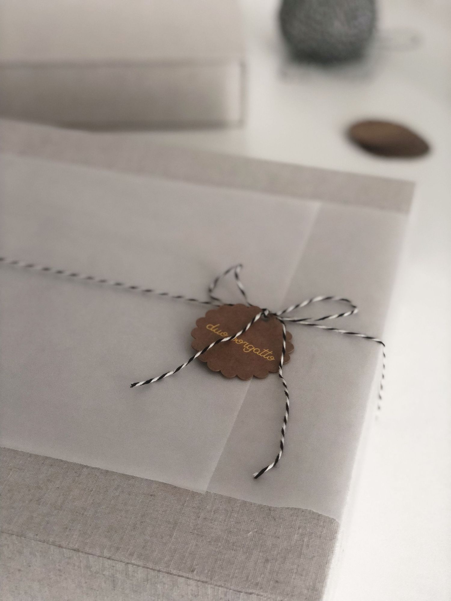 Delicate envelope sealed with twine and a copper wax seal on a white surface.
