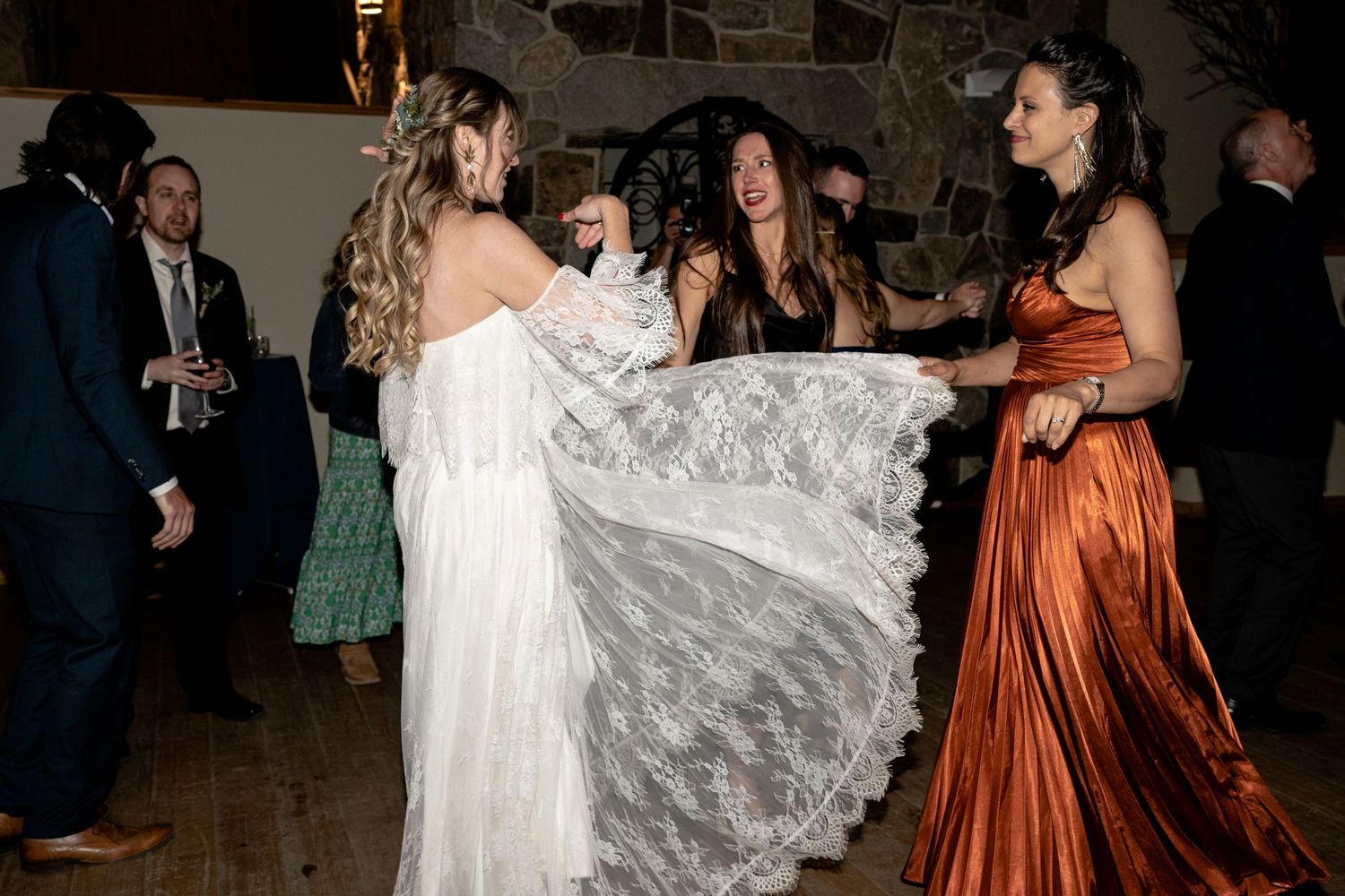 Wedding celebration with guests dancing and twirling in formal attire.