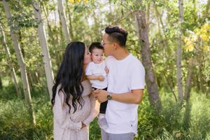 A family photoshoot sequence in a sunny wooded area with natural lighting.