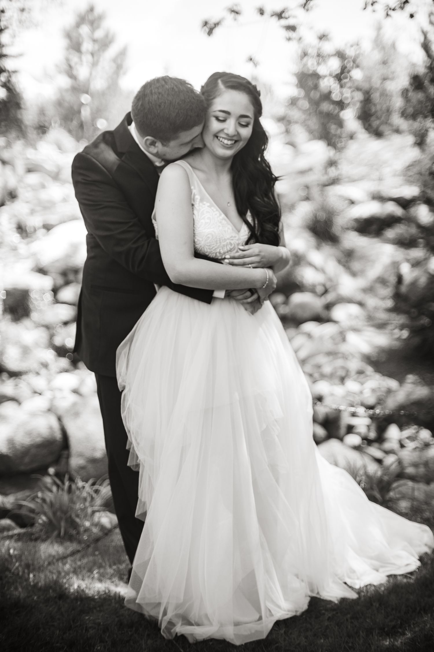 Cute couple snuggling in a garden.  Wedding photo.